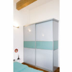 Gleittürschrank neben dem Bett