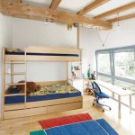 Kinderzimmer mit Stockbett mit ausziehbaren Bettkästen und Schreibtisch