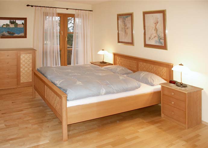 Doppelbett mit Holzgitter im Kopfteil