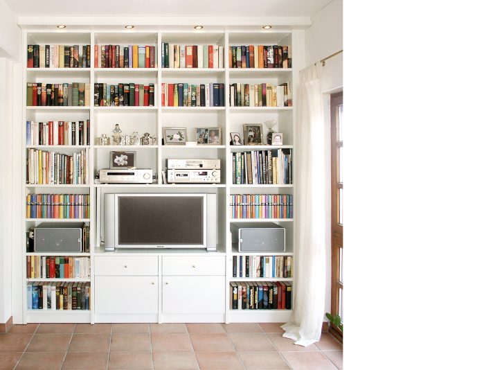 Bücherregal mit TV-Fach in der Mitte. Darunter sind Türen und Schubladen.
