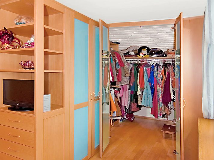 Schlafzimmer mit begehbarem Schrank: Geöffnete Schranktüren aus Buche mit Glaseinsatz