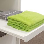 Der ausziehbare Fachboden für Kleidung hat vorne eine kleine Aufkantung, damit nichts hinunter rutscht
