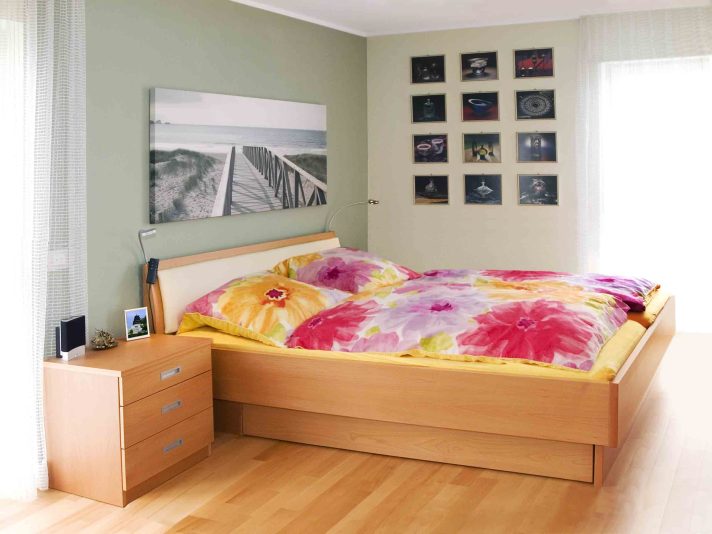 Bett mit gewölbtem Bettkopfteil und Nachtkästchen