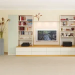 Zeitlos moderne Wohnwand mit großer Lücke für den Fernseher und Beleuchtung.