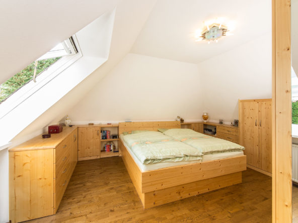 Schlafzimmerschrank und Bett in der Mansarde