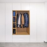 Einbaugarderobe mit einem mittig platzierten Einsatz aus Eiche - offenes Regal und Kleiderstange. Die weißen Schränke links und rechts bieten viel Platz für Schuhe und weitere Mäntel.