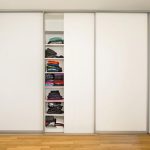 Ankleide mit weißem Einbauschrank: Mittlere Schiebetür geöffnet