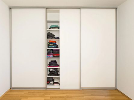 Ankleide mit weißem Einbauschrank: Mittlere Schiebetür geöffnet