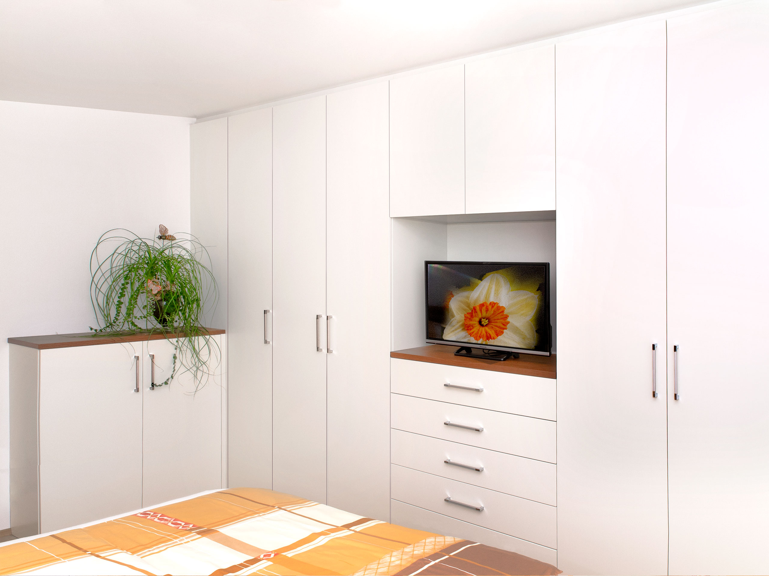 Einbauschrank mit direkt angeschlossener Kommode. Offenes Fach für den Fernseher.