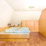 Schlafzimmerschrank und Bett in der Mansarde