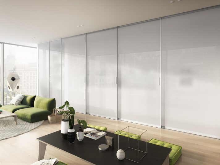 Transparenter Raumteiler aus Schiebetüren zwischen Wohnzimmer und Küche.