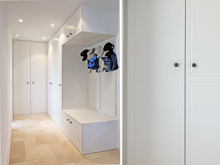 Weißer Einbauschrank im Flur mit offener Garderobe, Sitzbank und Hängeschrank.
