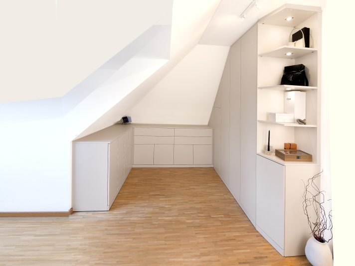 Schränke und Kommoden, in die Dachschräge eines Ankleideraums eingebaut