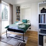 In diesem Jugendzimmer ist ein Schrankbett in eine weiße Regal-Schankkombination integriert.