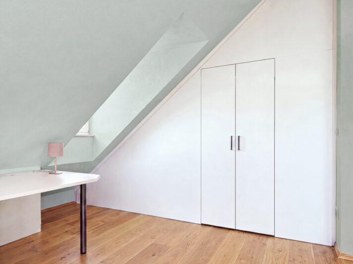 Dachschräge Schlafzimmer mit einem begehbaren Schrank einrichten. Bild von dieser Einrichtung wurde mit KI retouchiert.