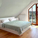 Dachschräge Schlafzimmer mit einem Doppelbett und mit weißen Kommoden einrichten. Bild von dieser Einrichtung wurde mit KI retouchiert.