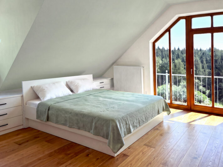 Dachschräge Schlafzimmer mit einem Doppelbett und mit weißen Kommoden einrichten. Bild von dieser Einrichtung wurde mit KI retouchiert.