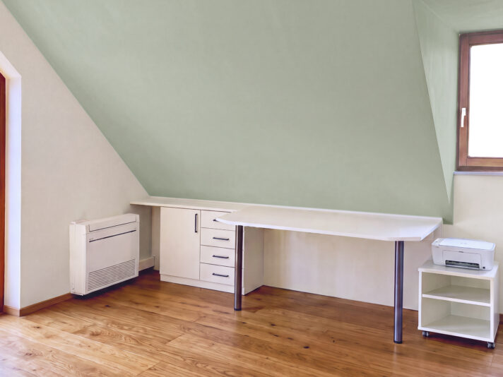Schreibtischllösung in einem Schlafzimmer unter der Dachschräge. Bild von dieser Einrichtung wurde mit KI retouchiert.
