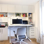 Einrichtung für Homeoffice mit höhenverstellbarem Schreibtisch, Regalen und Schränken.
