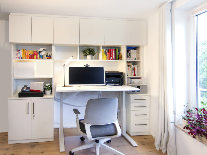 Einrichtung für Homeoffice mit höhenverstellbarem Schreibtisch, Regalen und Schränken.